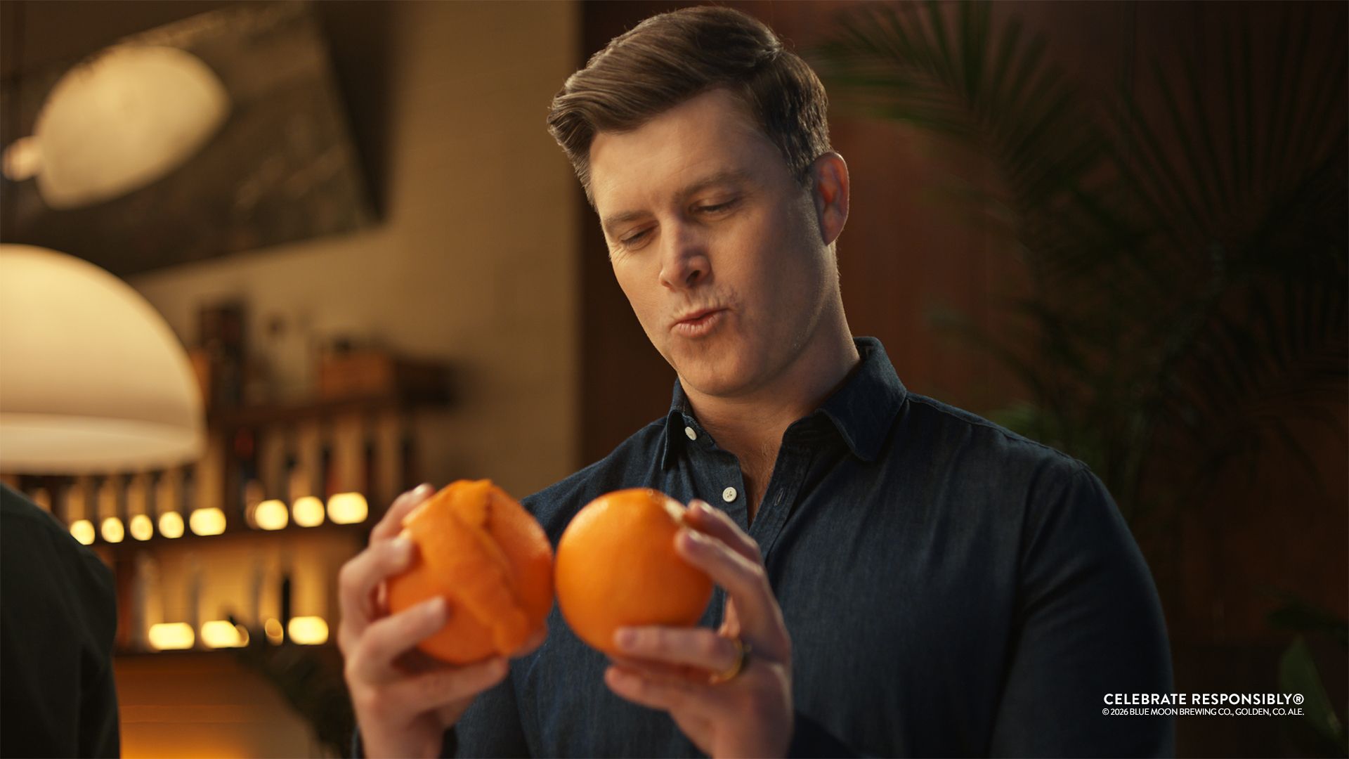 Colin Jost looking at oranges
